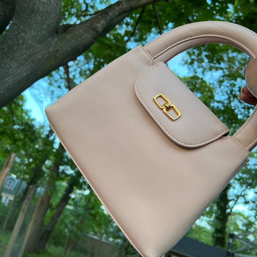 Pink handbag with chain strap and top handle